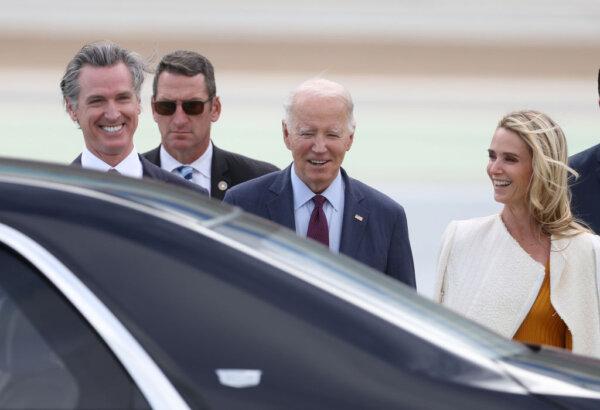 U.S. President Joe Biden (C) talks with California Governor Gavin Newsom (L) and his wife Jennifer Siebel Newsom (R) after arriving at San Francisco International Airport ahead of the APEC summit in San Francisco, Calif., on Nov. 14, 2023. (Justin Sullivan/Getty Images)