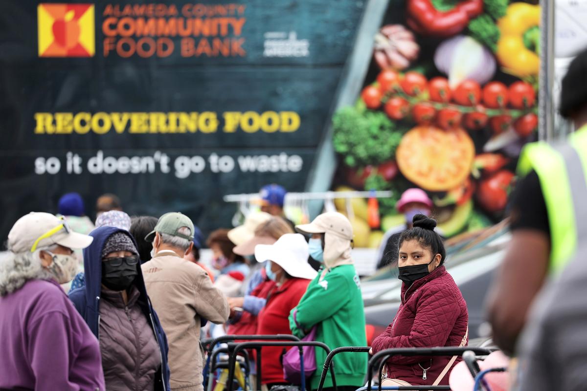  People wait in line to receive packages of food during an Alameda County Community Food Bank food giveaway in Oakland, Calif., on July 15, 2022. Record high inflation is forcing many to depend on food banks for basic needs as grocery prices continue to skyrocket. (Justin Sullivan/Getty Images)