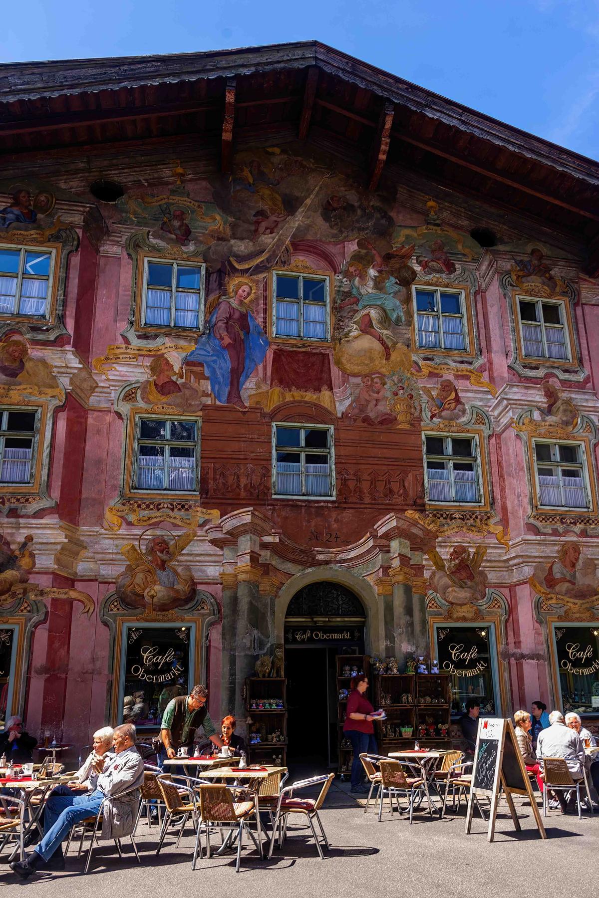 Tourists enjoy refreshments outside a café in the central Obermarkt during summer in Mittenwald, Germany. (DragonWen/Shutterstock)