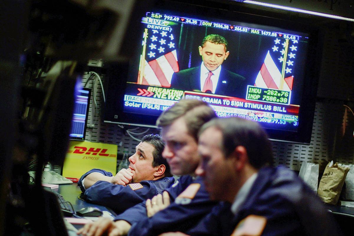  Traders work on the floor of the New York Stock Exchange as President Barack Obama is seen on television at the economic stimulus bill signing ceremony, in New York City on Feb. 17, 2009. Stocks dropped after President Obama signed the bill. (Mario Tama/Getty Images)