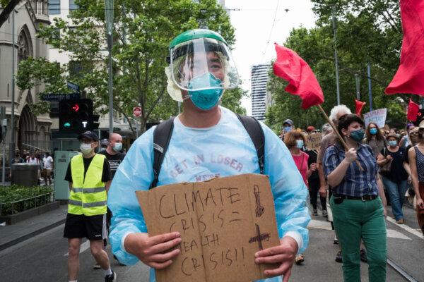  A climate change protestors is seen carry a placard in Melbourne, Australia, on Nov. 6, 2021. (Asanka Ratnayake/Getty Images)