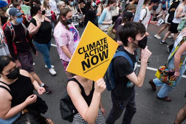 Climate change protestors are seen marching and changing as they carry placards in Melbourne, Australia, on Nov. 6, 2021. (Asanka Ratnayake/Getty Images)