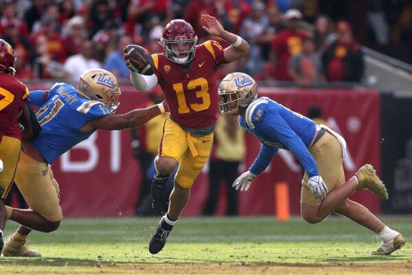 Gabriel Murphy (11) and Laiatu Latu (15) of the UCLA Bruins pressure Caleb Williams (13) of the USC Trojans from the pocket during the second half of a game in Los Angeles on Nov. 18, 2023. (Sean M. Haffey/Getty Images)