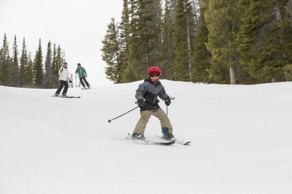 A young skier tries out a Wyoming mountain while his parents look on. (Courtesy of Visit Laramie)