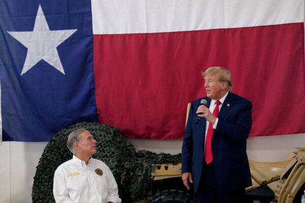 Texas Gov. Greg Abbott (L) listens as Republican presidential candidate and former President Donald Trump speaks to Texas state troopers and guardsmen during a Thanksgiving meal at the South Texas International Airport in Edinburg, Texas, on Nov. 19, 2023. (Eric Gay/AP Photo)