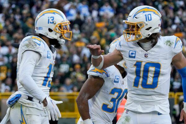 Los Angeles Chargers wide receiver Keenan Allen (13) and quarterback Justin Herbert (10) react after connecting on a touchdown pass against the Green Bay Packers during the second half of an NFL football game in Green Bay, Wis., on Nov. 19, 2023. (Morry Gash/AP Photo)