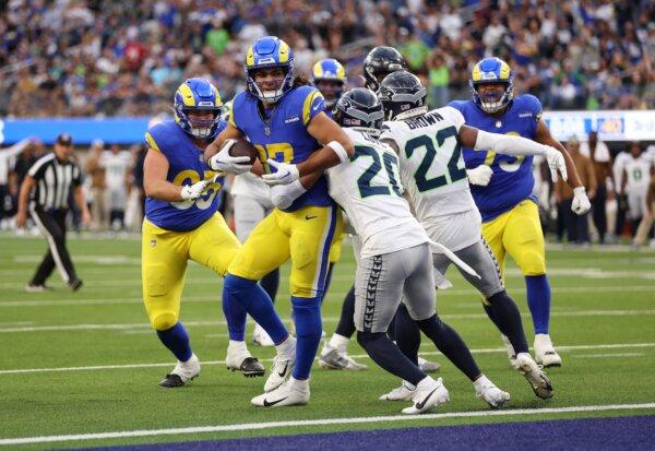 Puka Nacua (17) of the Los Angeles Rams scores a touchdown while defended by Julian Love (20) and Tre Brown (22) of the Seattle Seahawks during the second quarter in Inglewood, Calif., on Nov. 19, 2023. (Sean M. Haffey/Getty Images)