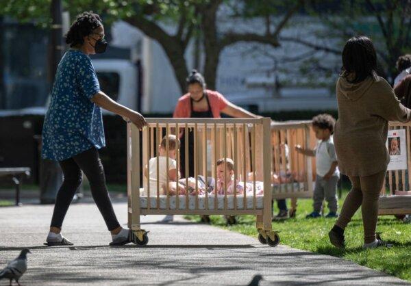 Little children prepare to leave a park with their day care class in a portable crib on a warm morning in Washington on April 12, 2023. (Andrew Caballero-Reynolds/AFP via Getty Images)