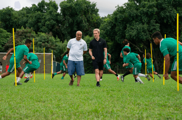 Coach Rongen (Michael Fassbender, R) and coach Oscar Knightley (Tavita) discuss soccer during a team practice, in “Next Goal Wins.” (Hilary Bronwyn Gayle/Searchlight Pictures)