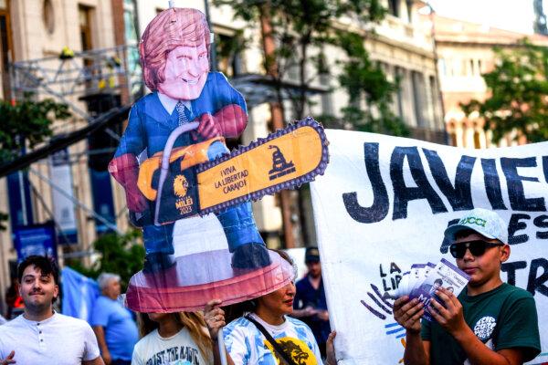 Supporters of presidential candidate Javier Milei hold a sign depicting Milei wielding a chainsaw, prior to his closing rally before the runoff election in Cordoba, Argentina, on Nov. 16, 2023. (Tomas Cuesta/Getty Images)