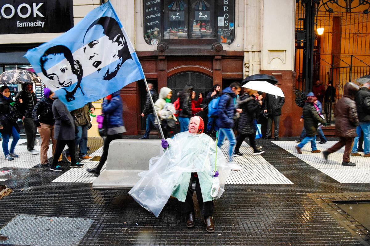 A woman waves a flag depicting Argentine three-time president Juan Domingo Peron and his wife Eva Peron, during a march for teachers' salary increase and against budget cuts in Argentine public universities, in Buenos Aires, Argentina, on Aug. 30, 2018. (Eitan Abramovich/AFP via Getty Images)