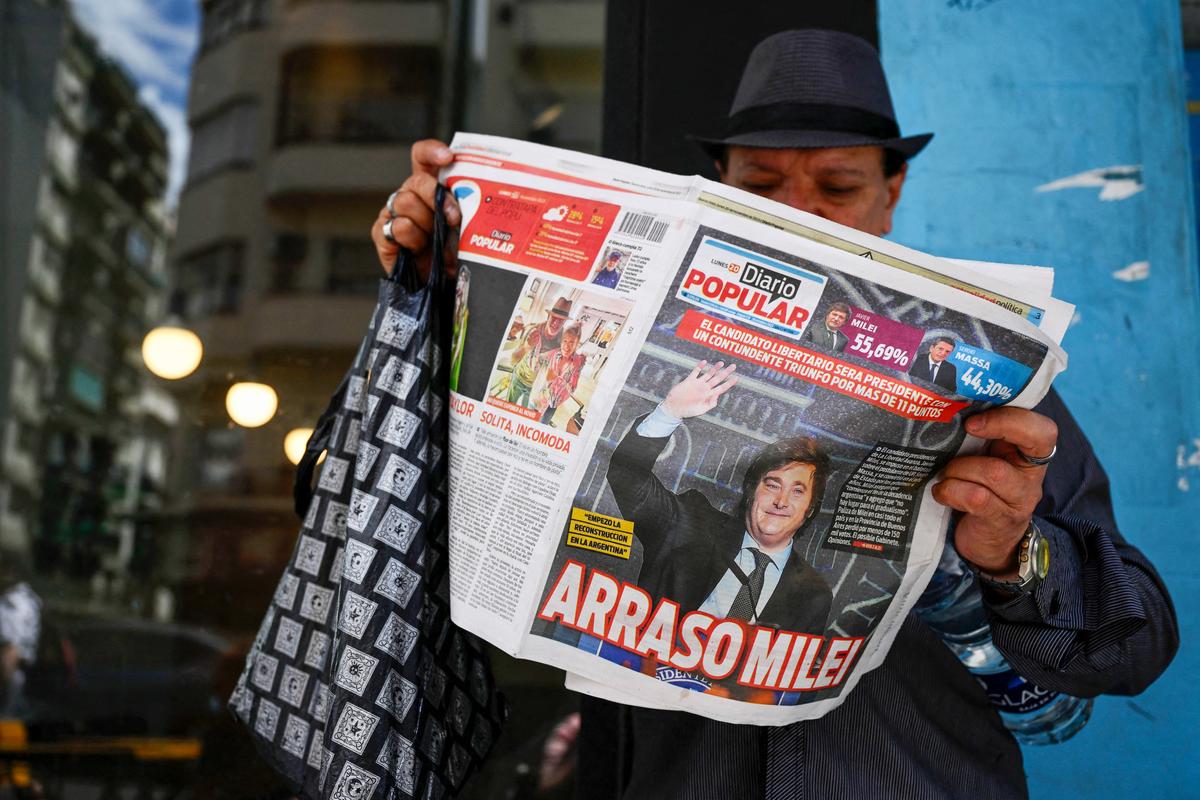 A man reads an Argentine newspaper on Nov. 20, 2023, in Buenos Aires, with its front page showing libertarian outsider Javier Milei, who swept to election victory, vowing to halt decades of economic decline in a country reeling from triple-digit inflation. (Luis Robayo/AFP via Getty Images)