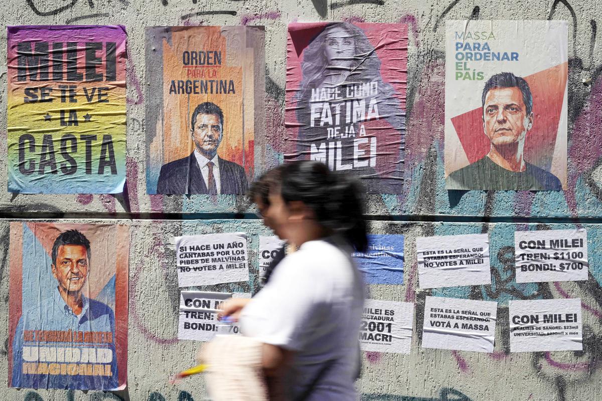 People pass by political propaganda in support of Argentina's economy minister and presidential candidate Sergio Massa and against candidate Javier Milei, in Buenos Aires, Argentina, on Nov. 15, 2023. (Juan Mabromata/AFP via Getty Images)