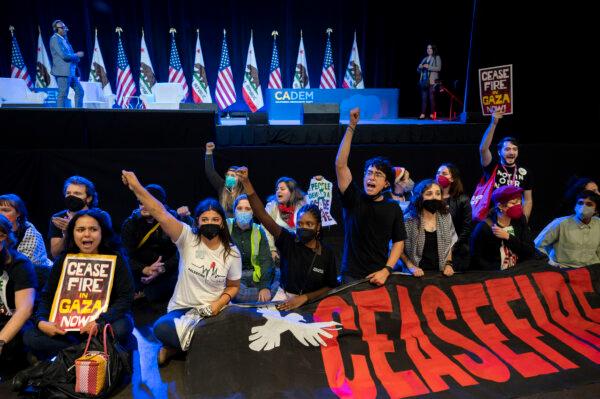 Pro-Palestinian demonstrators sit in front of the stage, disrupting the afternoon session of the 2023 California Democratic Party November State Endorsing Convention, Saturday, Nov. 18, 2023, at SAFE Credit Union Convention Center in Sacramento, Calif. (Lezlie Sterling/The Sacramento Bee via AP)