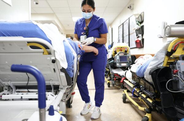 A lab technician cares for a patient in the emergency department at Providence St. Mary Medical Center in Apple Valley, Calif., on March 11, 2022. (Mario Tama/Getty Images)