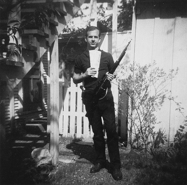 A photograph, given by Oswald to George de Mohrenschildt, of Oswald posing with his rifle, holstered pistol, and communist literature.