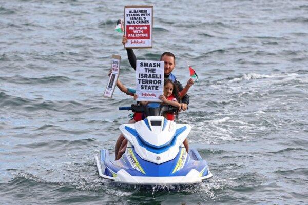 Members of the Australian Palestinian community hold placards as they sit on a jet ski during a protest at the Port Botany terminal in Sydney, Australia on Nov. 21, 2023. (David Gray/AFP via Getty Images)