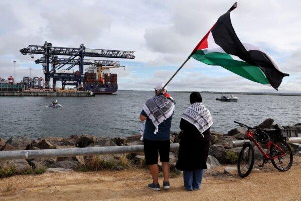Members of the Australian Palestinian community hold a Palestinian flag as others hold placards while on a jet ski during a protest at the Port Botany terminal in Sydney, Australia on Nov. 21, 2023. (David Gray/AFP via Getty Images)