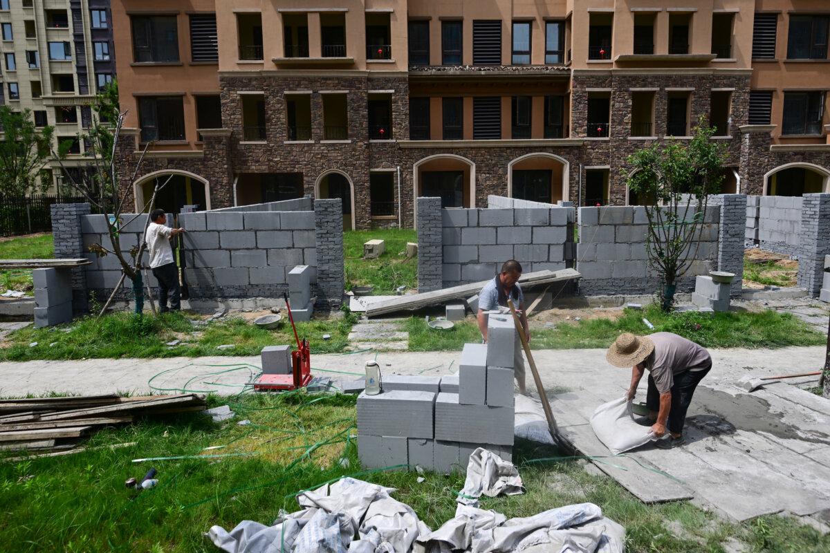 Men working at a complex of unfinished apartment buildings in Xinzheng City in Zhengzhou, China's central Henan province, on June 20, 2023. (Pedro Pardo / AFP)
