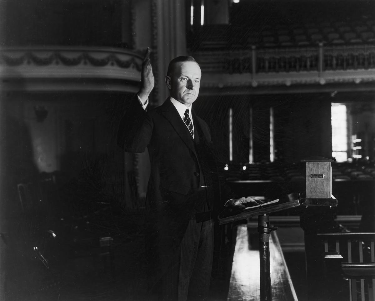 President Coolidge raises his right hand during his swearing-in ceremony in Washington, D.C. (Photo by Hulton Archive/Getty Images)