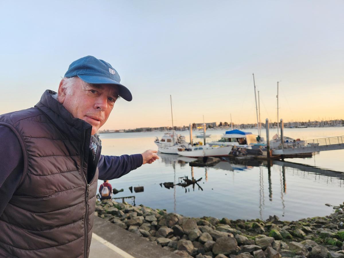  Former Oakland Marinas and Alameda Harbormaster Brock de Lappe points to a group of illegally anchored derelict boats along the Oakland Estuary on Nov. 13, 2023. (Allan Stein/The Epoch Times)