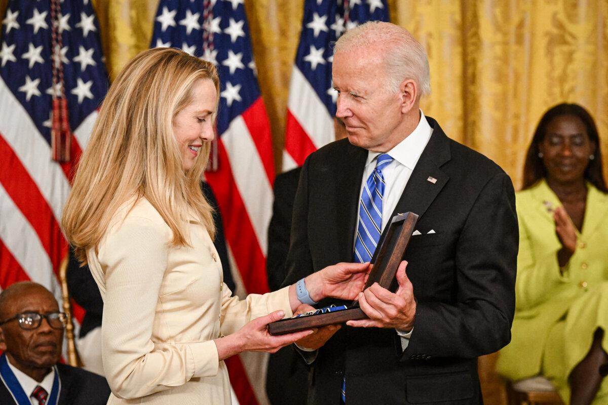President Joe Biden presents businesswoman Laurene Powell Jobs with the Presidential Medal of Freedom for her late husband Steve Jobs, in the White House, on July 7, 2022. (Saul Loeb/AFP via Getty Images)