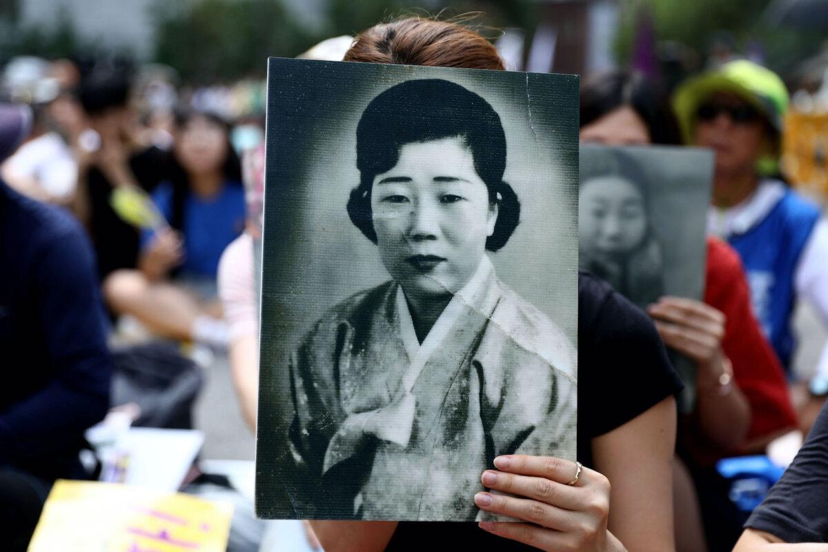 A woman holds a portrait of deceased former South Korean "comfort women" during a rally to mark the 73rd National Liberation Day in front of Japanese embassy in Seoul, South Korea on Aug. 15, 2018. (Chung Sung-Jun/Getty Images)