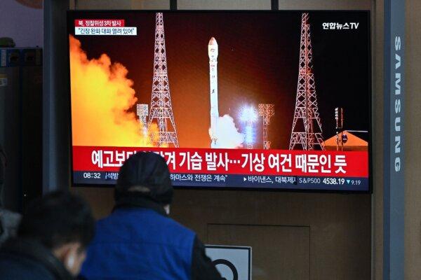 People watch a television screen showing a news broadcast with a picture of North Korea's latest satellite-carrying rocket launch at a railway station in Seoul on Nov. 22, 2023. (Jung Yeon-Je/AFP via Getty Images)