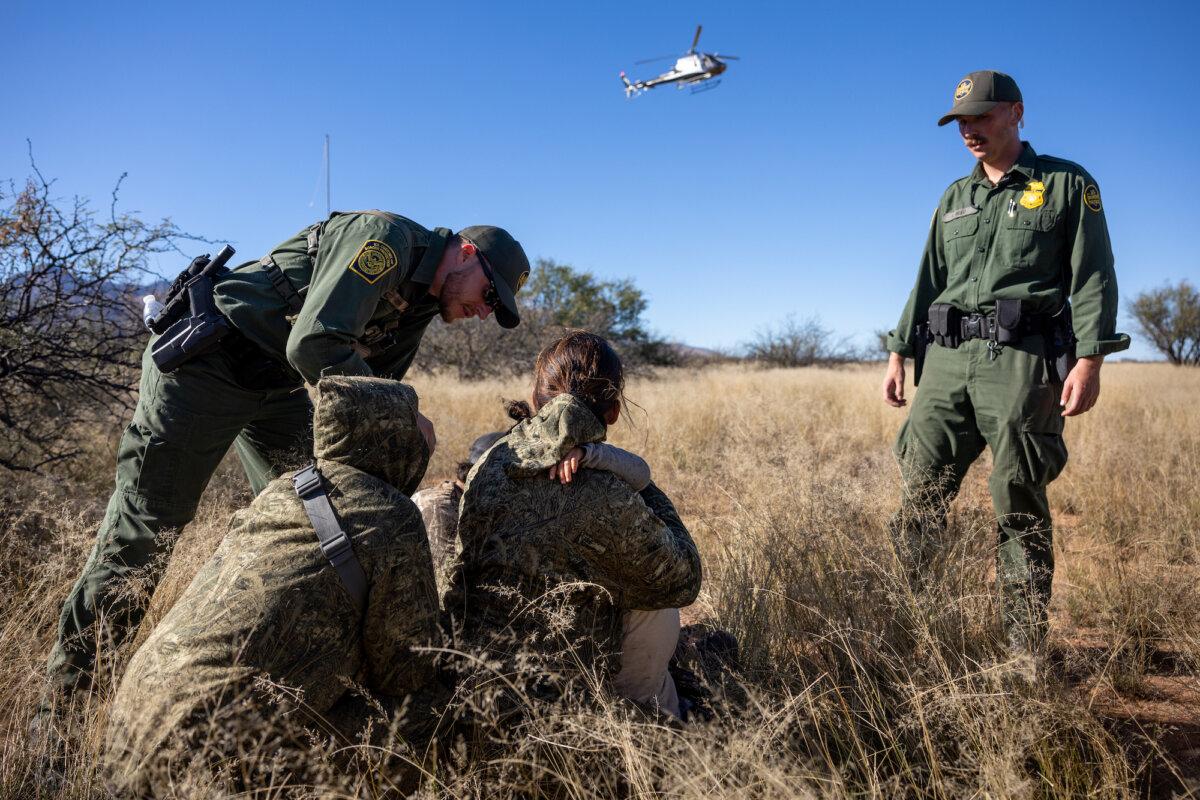 U.S. Customs and Border Patrol agents detain a camouflaged family from Mexico after they had illegally crossed the U.S.–Mexico border near Naco, Arizona, on Nov. 4, 2022. (John Moore/Getty Images)