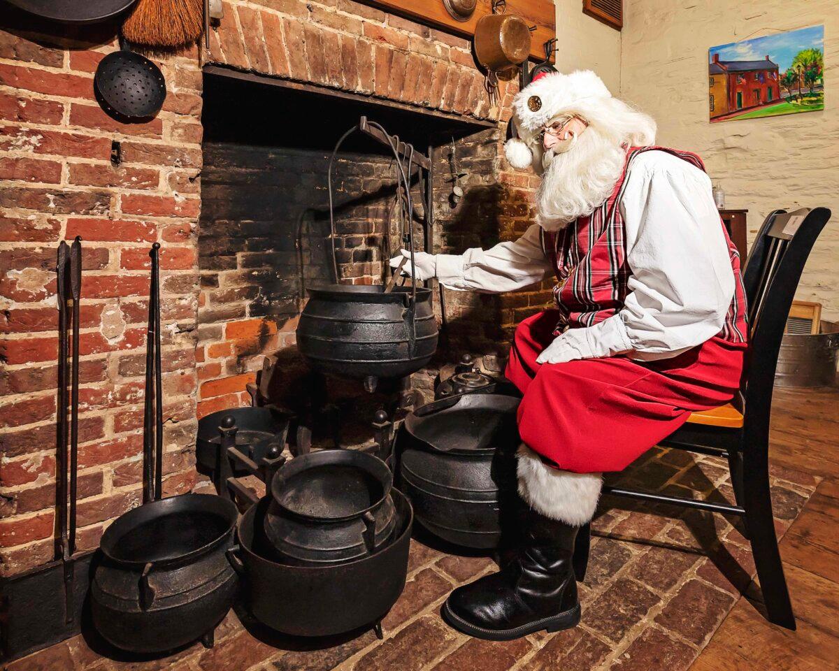 Mr. Brown re-enacts cooking carrots for reindeer, at the Fauquier History Museum at the Old Jail in Warrenton, Va. The photo-op was for his recently published children’s historical fiction, “Santa Visits the Old Jail.” (Reformed Photography)