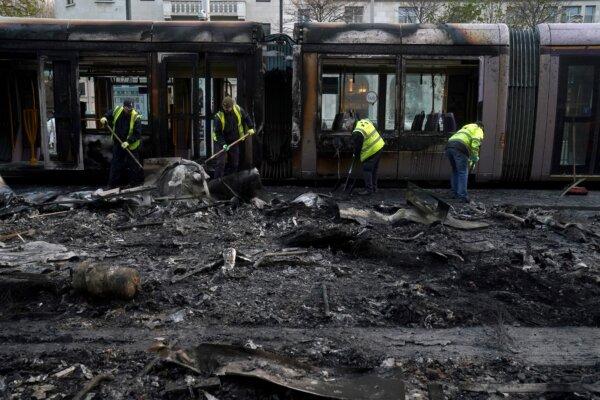 Debris is cleared from a burned-out Luas and bus in the aftermath of a riot the night before, on O'Connell Street in Dublin on Nov. 24, 2023. (Brian Lawless/PA Wire)