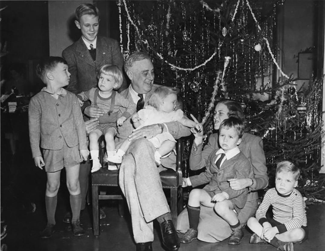 President Roosevelt surrounded by his grandchildren at Hyde Park, New York, on Dec. 24, 1943. (L–R) Franklin D. Roosevelt III, Curtis “Buzzie,” Christopher duPont Roosevelt, President Roosevelt, Ann Roosevelt, Eleanor “Sistie” Dall, John Boettiger, and Haven Roosevelt. (Franklin D. Roosevelt Presidential Library and Museum)