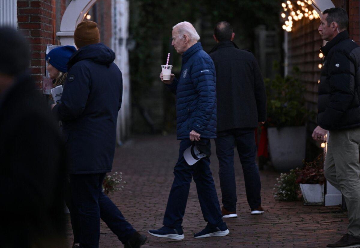 President Joe Biden carries a drink as he visits local shops with relatives in Nantucket, Massachusetts, on Nov. 25, 2023. (Brendan Smialowski/AFP/Getty Images)