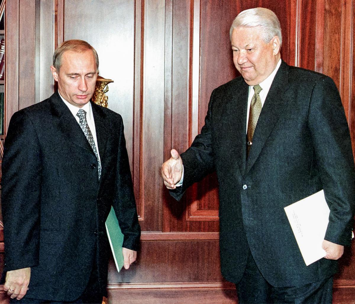 Russian President Boris Yeltsin (R) invites Prime Minister Vladimir Putin (L) to start the talks during their meeting in the Kremlin in Moscow, on Aug. 17, 1999. (STF/POOL/AFP via Getty Images)