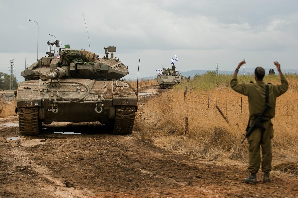 Israeli armor personnel carriers move in formation near the Israeli border with Lebanon, near Amiad, Israel, on Oct. 15, 2023. (Amir Levy/Getty Images)
