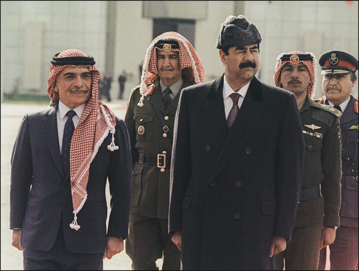 Iraqi President Saddam Hussein (R) and King Hussein of Jordan review the honor guard upon Saddam Hussein's arrival for the Arab cooperation council meeting in Amman, Jordan, on Feb. 24, 1990. (MIKE NELSON/AFP via Getty Images)