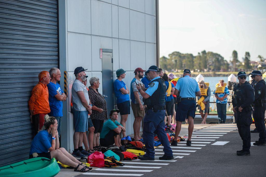 Police officers question protestors after being arrested on the water as they attempted to blockade the access to the coal port in protest for climate action in Newcastle, Australia on Nov. 26, 2023. (Roni Bintang/Getty Images)