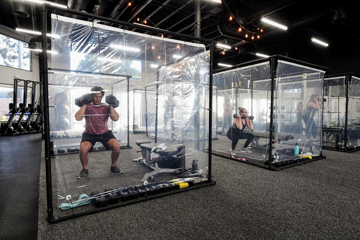  People exercise at Inspire South Bay Fitness behind plastic sheets in their workout pods while social distancing in Redondo Beach, Calif., on June 15, 2020. (FREDERIC J. BROWN/AFP via Getty Images)