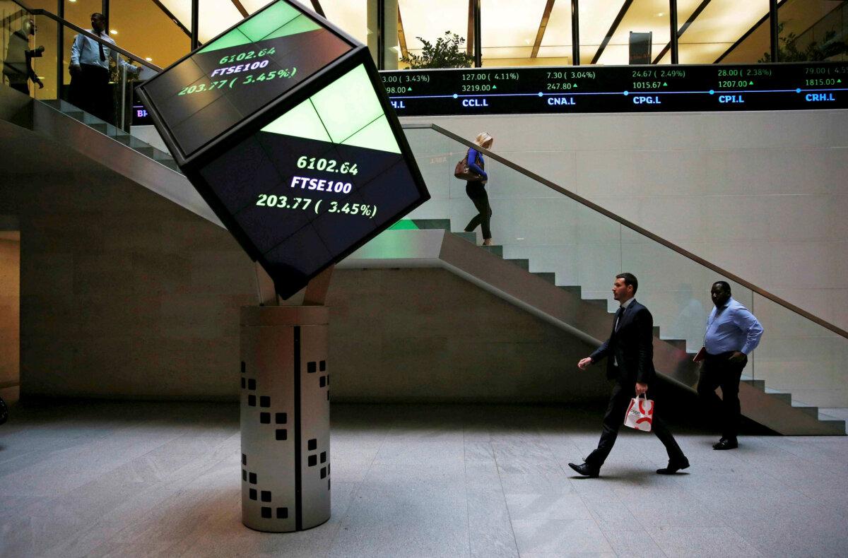 People walk through the lobby of the London Stock Exchange in London on Aug. 25, 2015. (Suzanne Plunkett/Reuters)