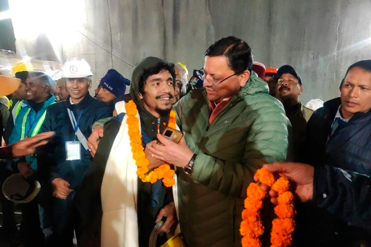 Pushkar Singh Dhami (R), chief minister of the state of Uttarakhand, greets a worker rescued from the site of an under-construction road tunnel that collapsed in Silkyara in the northern Indian state of Uttarakhand, India, on Nov. 28, 2023. (Uttarakhand State Department of Information and Public Relations via AP)