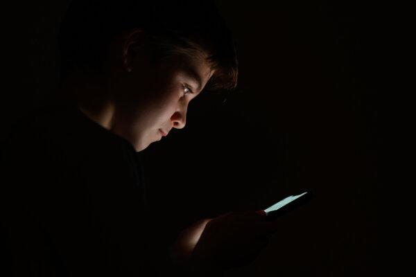 A teenage child looks at the screen of a mobile phone on January 17, 2023 in London, England. (Leon Neal/Getty Images)
