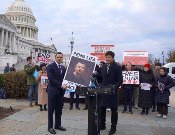 Rep. Mike Gallagher (R-Wis.) (left), chair of the House Select Committee on the Chinese Communist Party (CCP), and Zhou Fengsuo, executive director of Human Rights in China, hold a poster supporting the Nobel Peace Prize nomination of Peng Lifa, also known as "the bridge man" for his one-man protest on the Beijing Sitong Bridge in 2022 against the authoritarian rule of the CCP, outside the U.S. Capitol on Nov. 29, 2023. (Terri Wu/The Epoch Times)