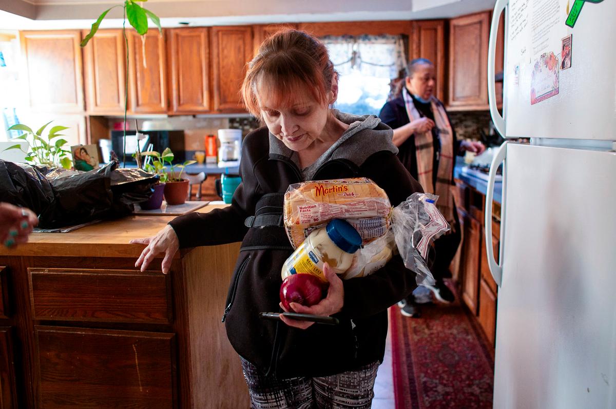 A woman carries food from the kitchen of "Strengthen Our Sisters," a shelter for women who have suffered domestic violence, in Paterson, N.J., on Feb. 25, 2021. (Photo by Kena Betancur/AFP via Getty Images)