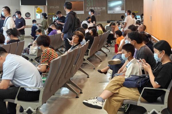 Patients line up for an emergency pre-check at the new pediatric building of Xinhua Hospital in Shanghai on the night of Sept. 25, 2023. The emergency and night care outpatient hall is crowded with children and family members waiting for treatment. (CFOTO/Future Publishing via Getty Images)