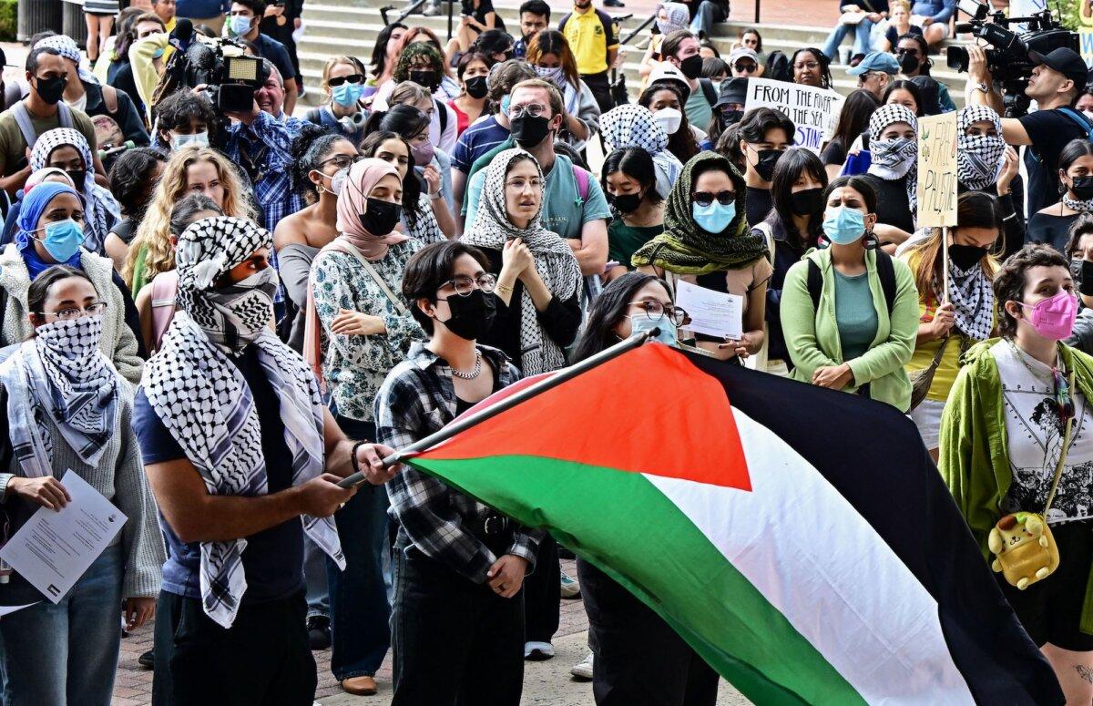 A person holds a Palestinian flag as students participate in a “Walkout to fight Genocide and Free Palestine” at Bruin Plaza at UCLA (University of California, Los Angeles) in Los Angeles on Oct. 25, 2023. (Photo by Frederic J. Brown/AFP via Getty Images)