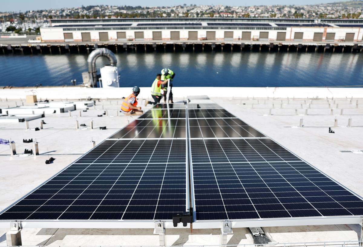 Workers install solar panels at a four-acre solar rooftop atop AltaSea's research and development facility at the Port of Los Angeles, in the San Pedro neighborhood of Los Angeles on April 21, 2023. (Mario Tama/Getty Images)