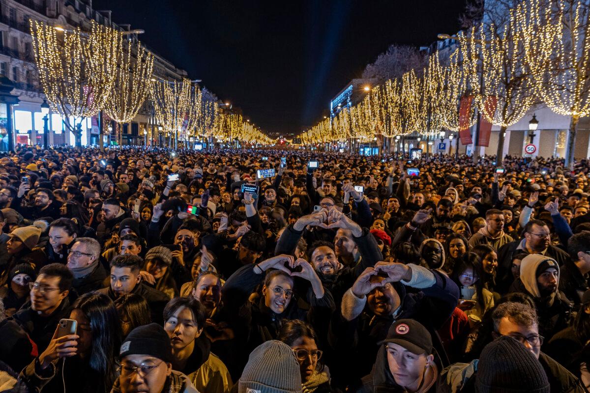 World Celebrates the Arrival of 2024 | USNN World News  People watch a light show projected on the Arc de Triomphe as they celebrate New Year's on the Champs Elysees in Paris, France, on Dec. 31, 2023. (Aurelien Morissard/AP Photo)