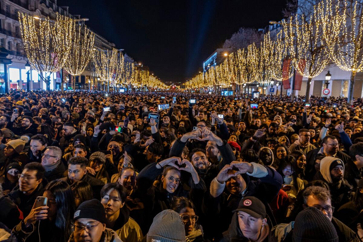  People watch a light show projected on the Arc de Triomphe as they celebrate New Year's on the Champs Elysees in Paris, France, on Dec. 31, 2023. (Aurelien Morissard/AP Photo)