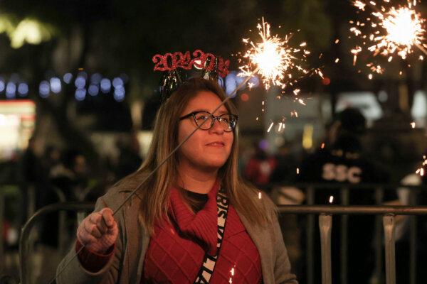  A woman holds a sparkler during the concert of Panamanian musician, singer and politician Ruben Blades at the monument Angel de la Independencia during the New Year 2024 celebration in Mexico City on Dec. 31, 2023. (IVAN CASTANEIRA/AFP via Getty Images)