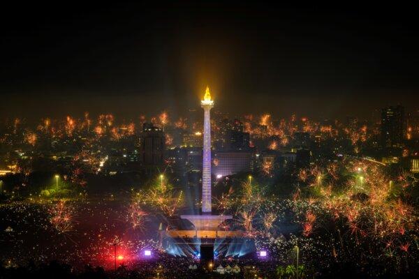  Fireworks explode over the city to usher in the New Year, as revellers gather around as the lit National Monument of Indonesia (MONAS) in Jakarta on Jan. 1, 2024. (Yasuyoshi CHIBA/AFP)